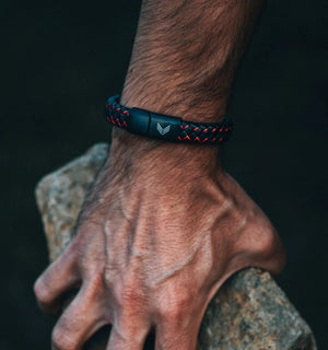 Vertig Magnetic Wide Leather Bracelet Black-Red on a man's wrist. Accentuates modern style with its black leather and vibrant red detail.