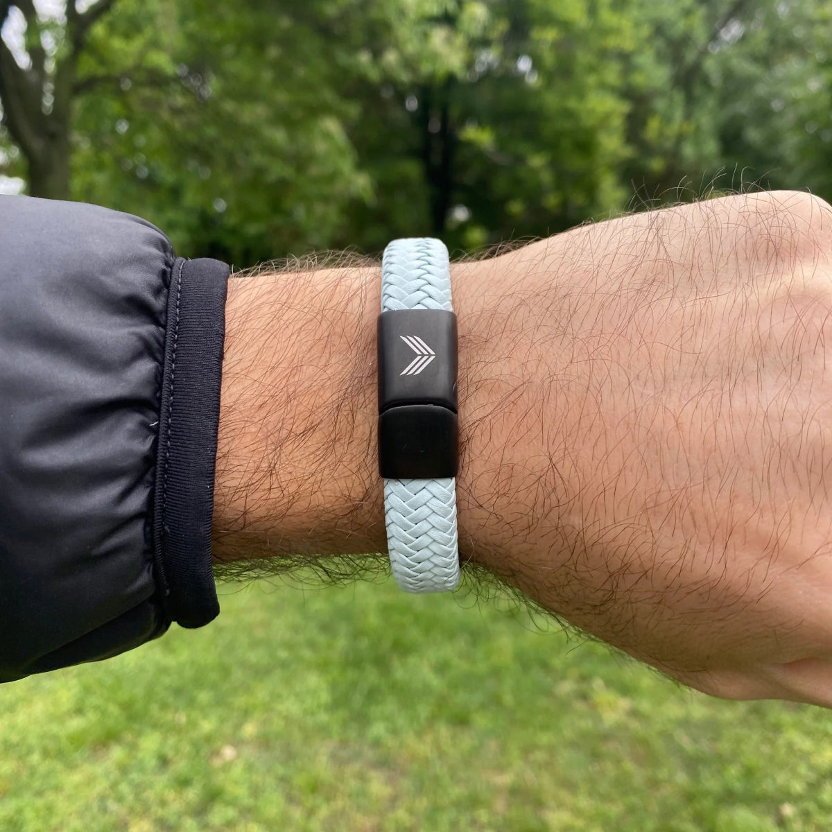 Vertig Magnetic Wide Leather Bracelet Grey on a man&#39;s wrist. Accentuates modern style with its bold leather band and versatile hue.