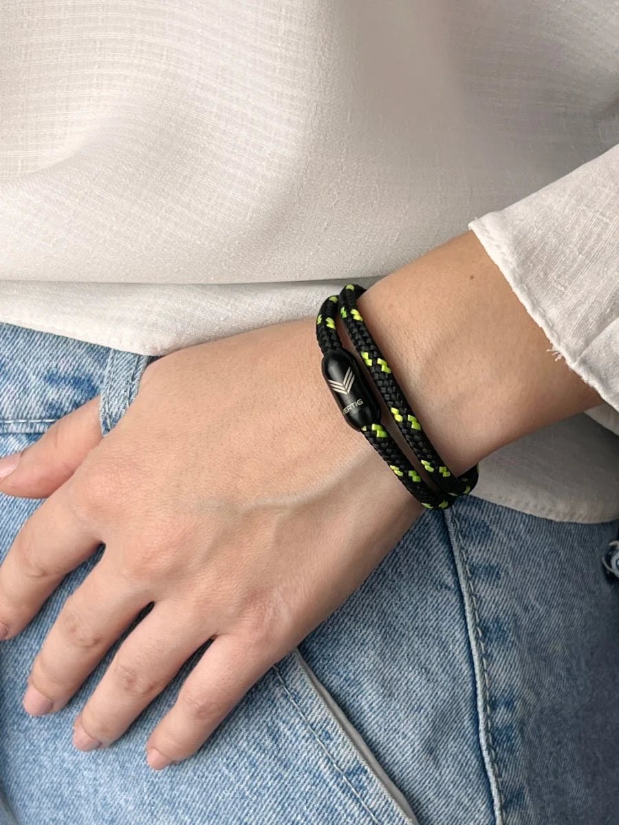 Vertig Magnetic Nautical Paracord Bracelet Black Neon on a woman&#39;s arm. Comfortable fit highlighting the unique neon weave.