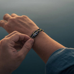 Vertig Magnetic Nautical Paracord Bracelet Black Neon on a man's forearm. Durable design, perfect for outdoor adventures.