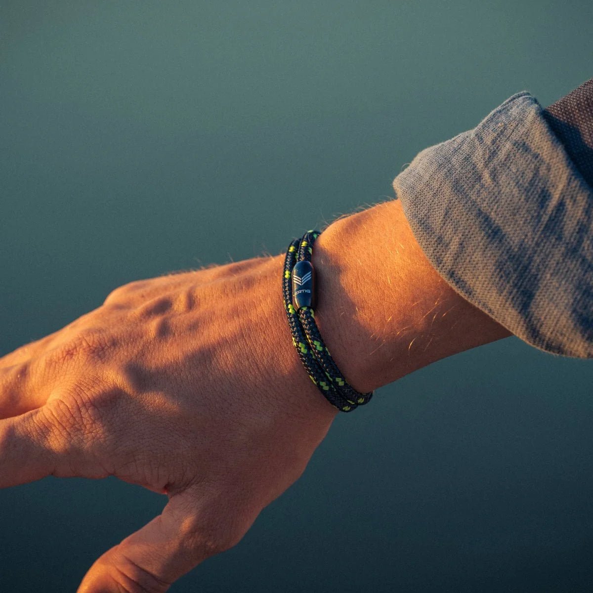 Vertig Magnetic Nautical Paracord Bracelet Black Neon on a man&#39;s wrist. Adds a bold, sporty statement to any outfit.