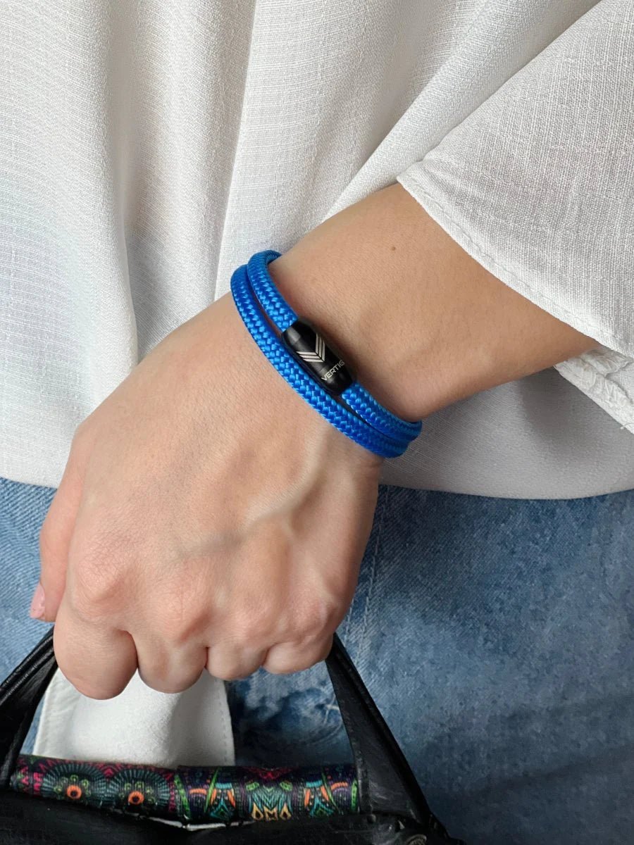 Vertig Magnetic Nautical Paracord Bracelet Blue on a woman&#39;s arm. Comfortable fit, highlighting its versatile shade.
