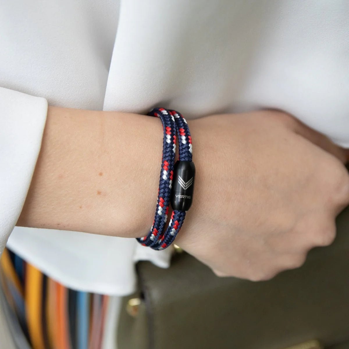 Vertig Magnetic Nautical Paracord Bracelet Blue-Red on a woman&#39;s wrist. Stylish, durable outdoor accessory.