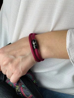 Vertig Magnetic Nautical Paracord Bracelet Burgundy on a woman&#39;s arm. Comfortable fit, highlighting its elegant hue.