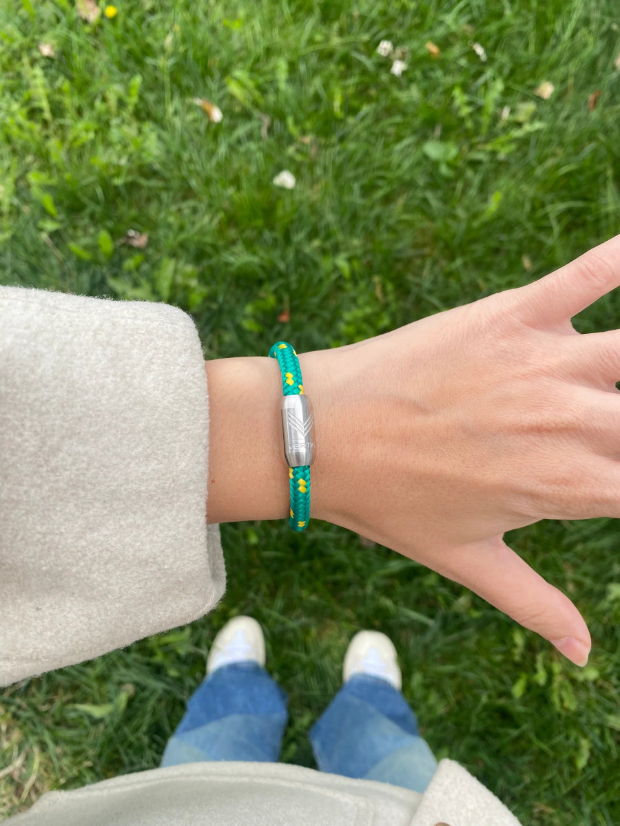 Vertig Magnetic Nautical Paracord Bracelet Green Yellow (Slim) on a woman&#39;s wrist. A striking accessory for a nature-inspired look.