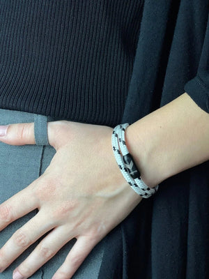 Vertig Magnetic Nautical Paracord Bracelet White Black on a woman's arm. Comfortable fit highlighting the distinct weave pattern.