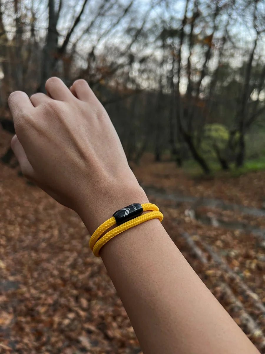 Vertig Magnetic Nautical Paracord Bracelet Yellow on a woman&#39;s wrist. Stylish, durable outdoor accessory.