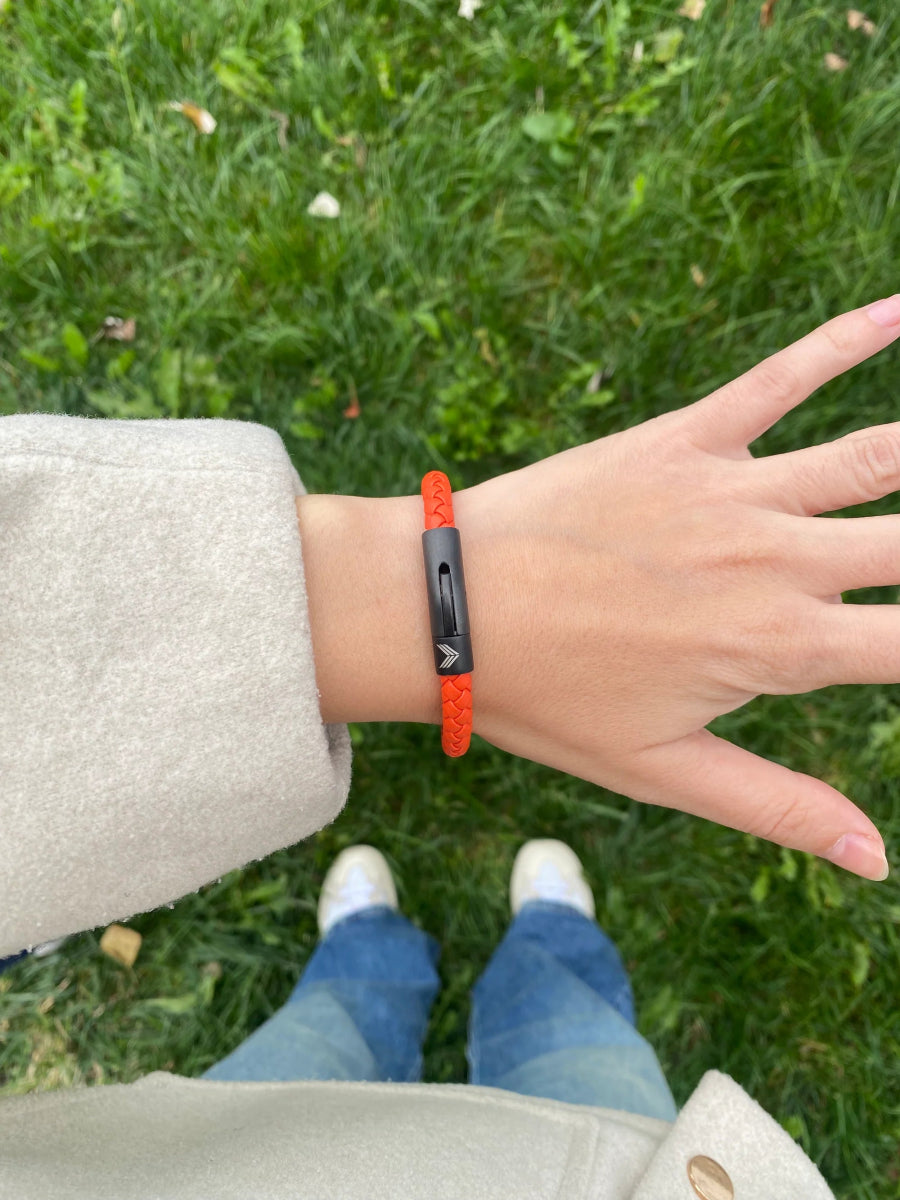Vertig Leather Bracelet Orange on a woman&#39;s wrist. Adds a lively touch, emphasizing its slender profile and rich orange hue.