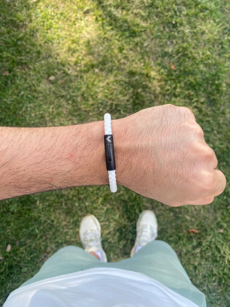 Vertig Leather Bracelet White on a man&#39;s wrist. Accentuates a clean style with its slim white leather and secure closure.