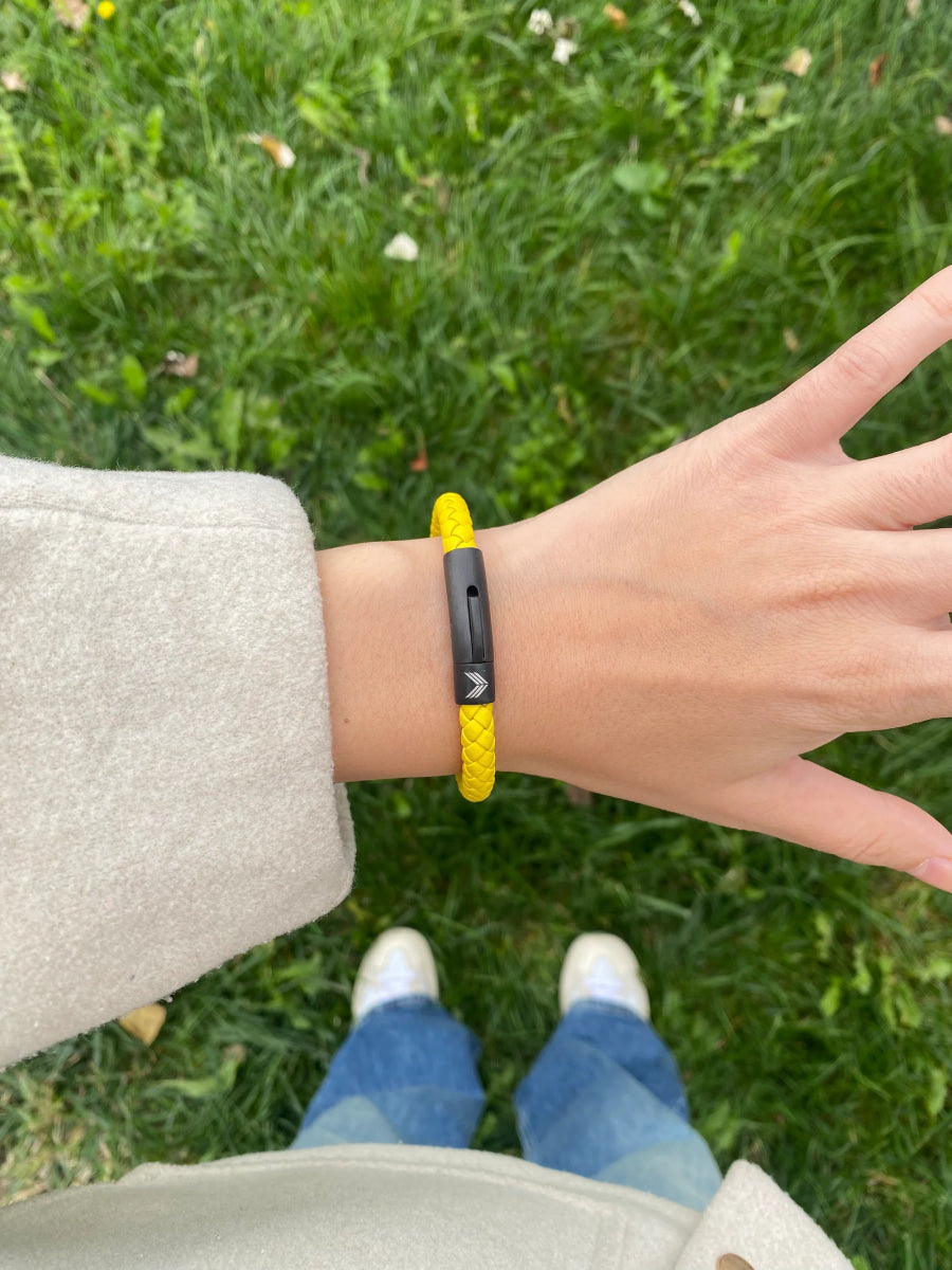 Vertig Leather Bracelet Yellow on a woman&#39;s wrist. Adds a lively touch, emphasizing its slender profile and rich yellow hue.
