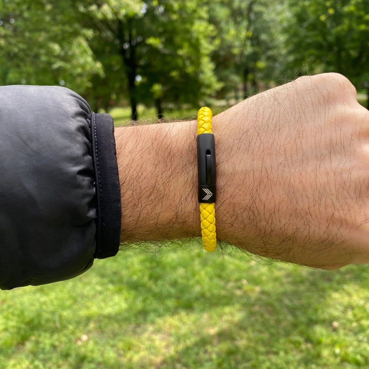 Vertig Leather Bracelet Yellow on a man&#39;s wrist. Accentuates vibrant style with its slim yellow leather and secure closure.