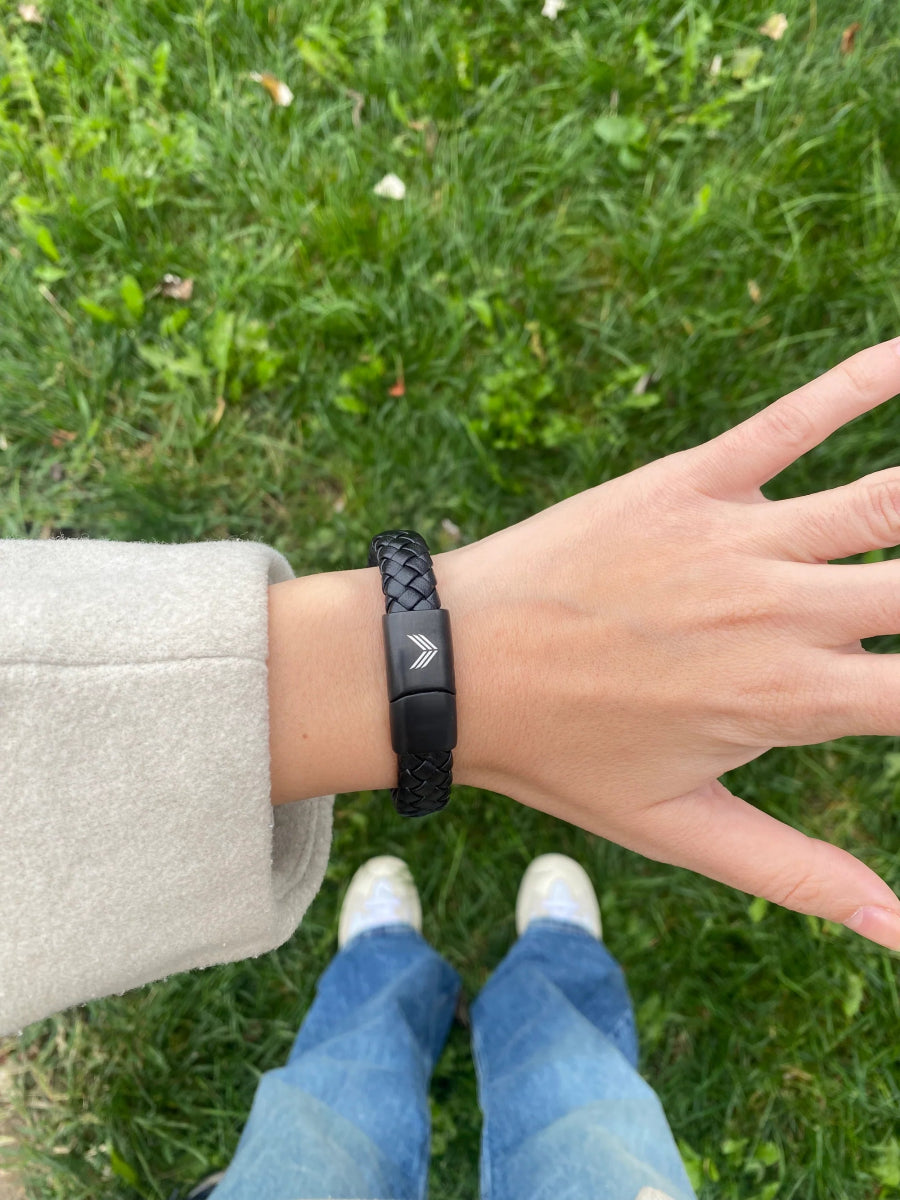 Vertig Magnetic Wide Leather Bracelet Black on a woman&#39;s wrist. Adds an edgy, confident touch with its wide, versatile black leather design.