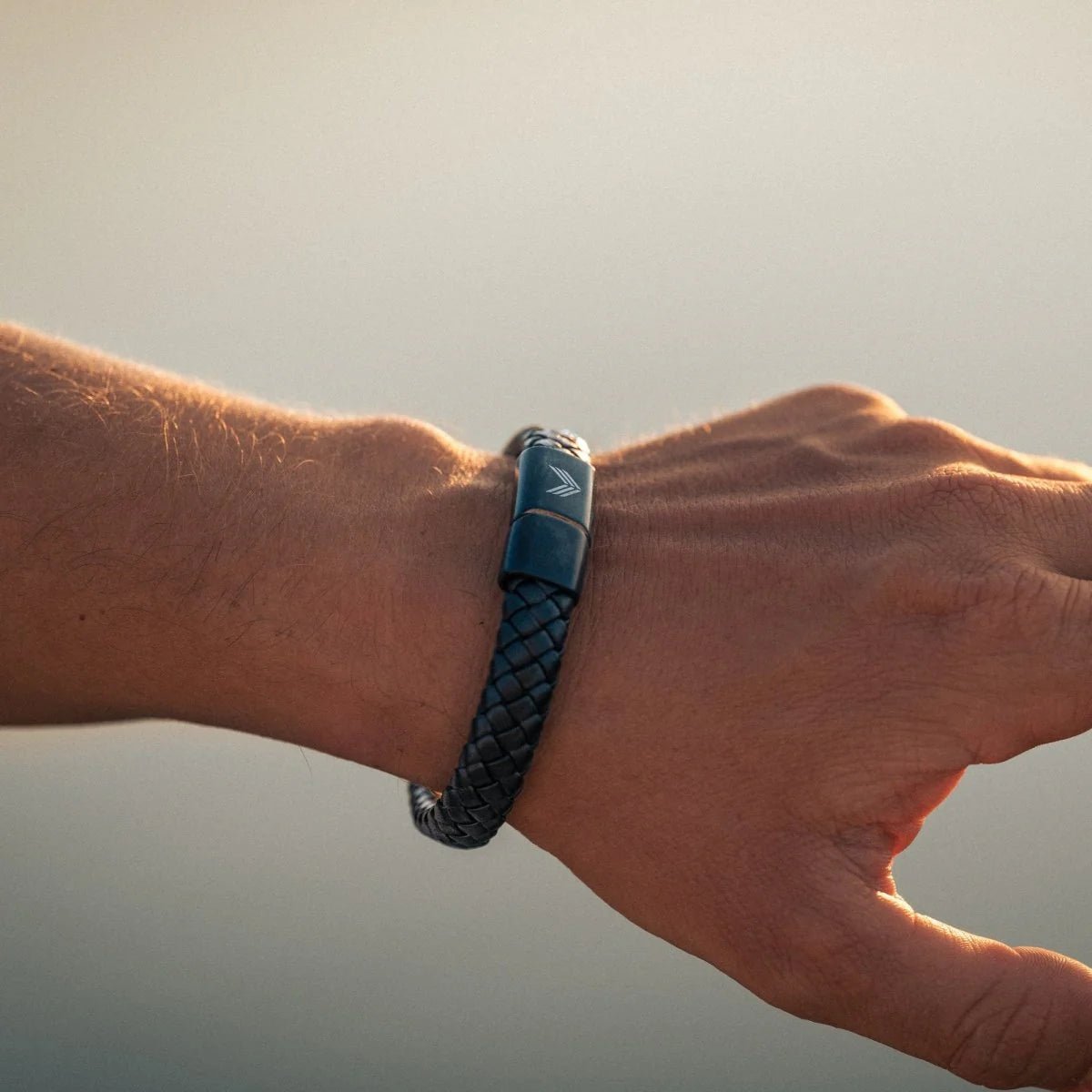 Vertig Magnetic Wide Leather Bracelet Black on a man&#39;s wrist. Accentuates masculine style with its bold leather band and magnetic clasp.