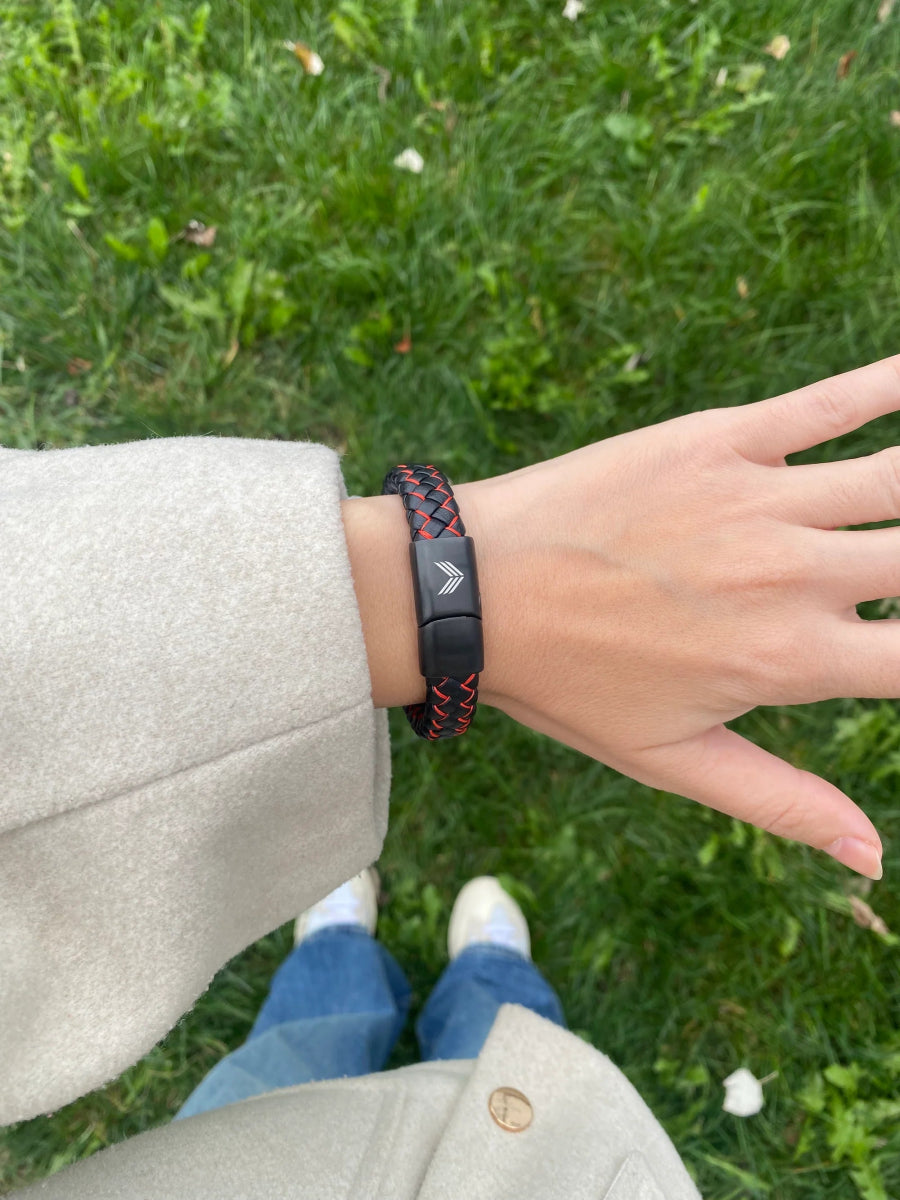 Vertig Magnetic Wide Leather Bracelet Black-Red on a woman&#39;s wrist. Creates a confident, contemporary statement with its bold design.