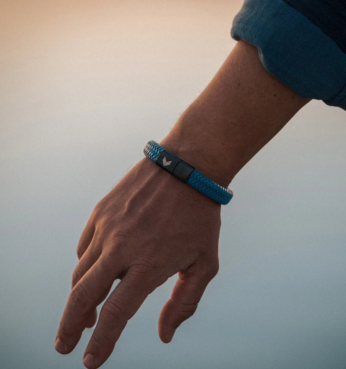 Vertig Magnetic Wide Leather Bracelet Blue on a man&#39;s wrist. Enhances masculine attire with its bold leather band and refined appeal.
