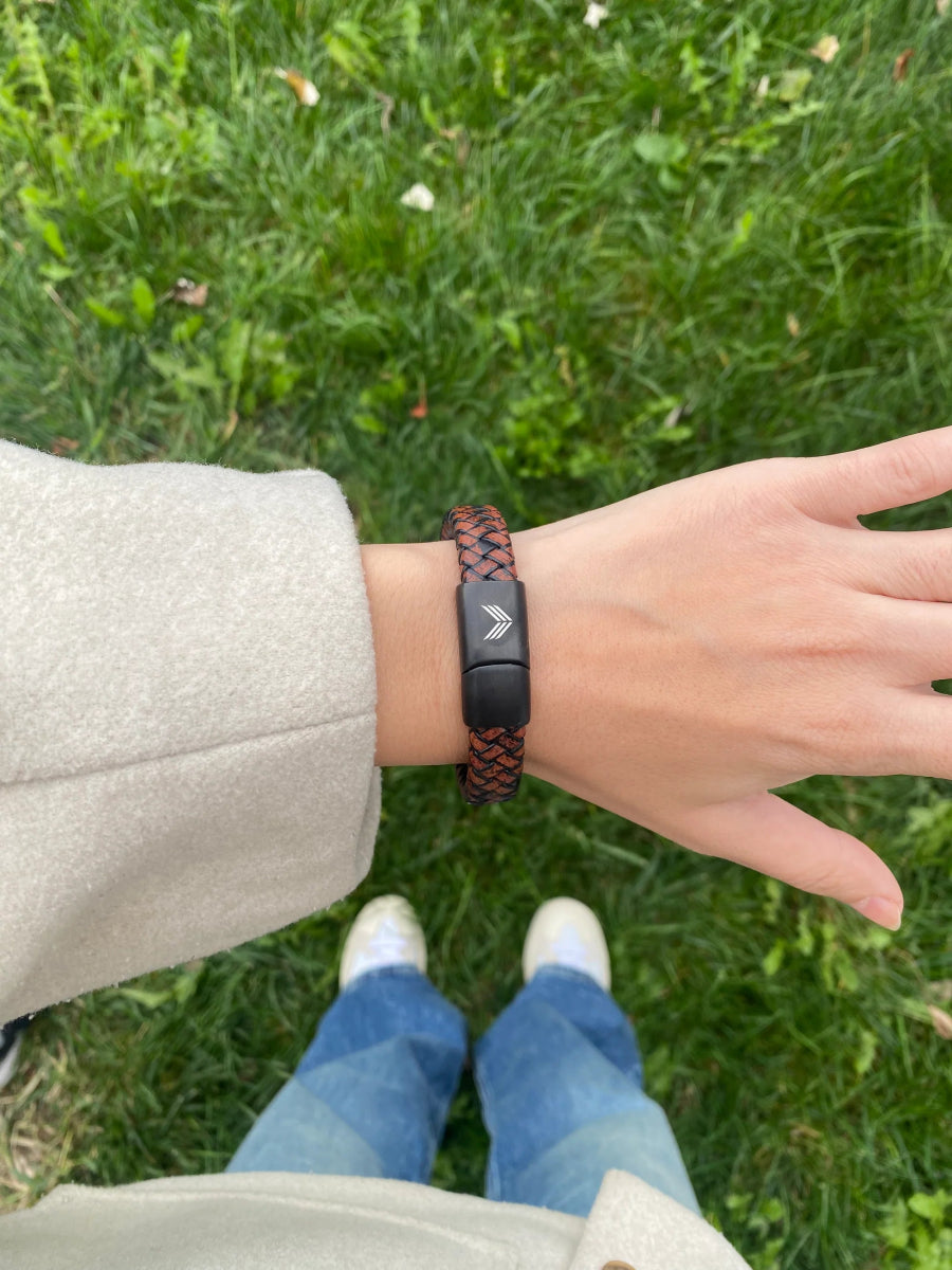 Vertig Magnetic Wide Leather Bracelet Brown on a woman&#39;s wrist. Creates an authentic, confident statement with its wide, warm brown leather.