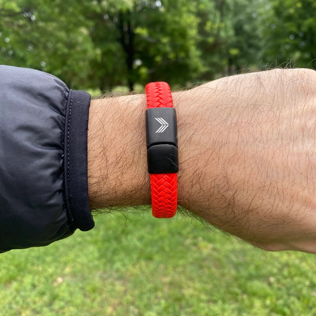 Vertig Magnetic Wide Leather Bracelet Orange on a man&#39;s wrist. Displays its secure magnetic closure and premium leather texture.