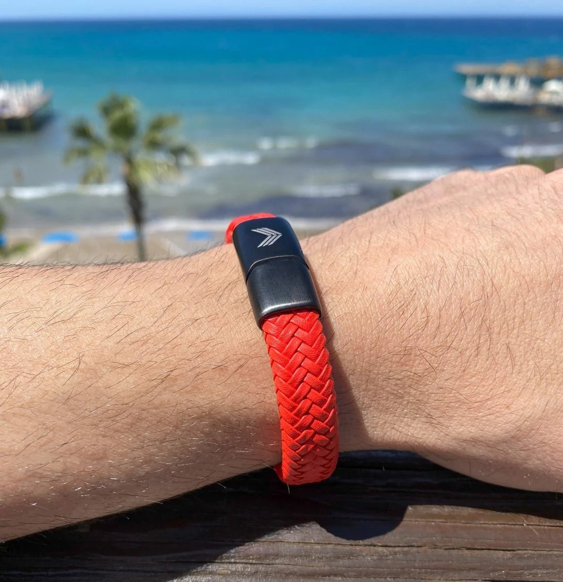 Vertig Magnetic Wide Leather Bracelet Orange on a man&#39;s forearm. Highlights its comfortable fit and wide leather design.